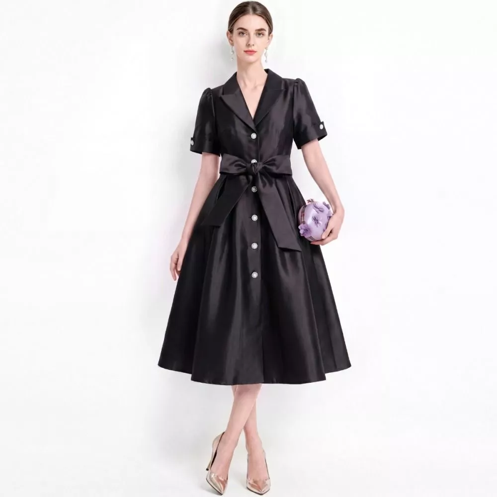Modella indossa abito nero elegante vista frontale con borsa lilla
