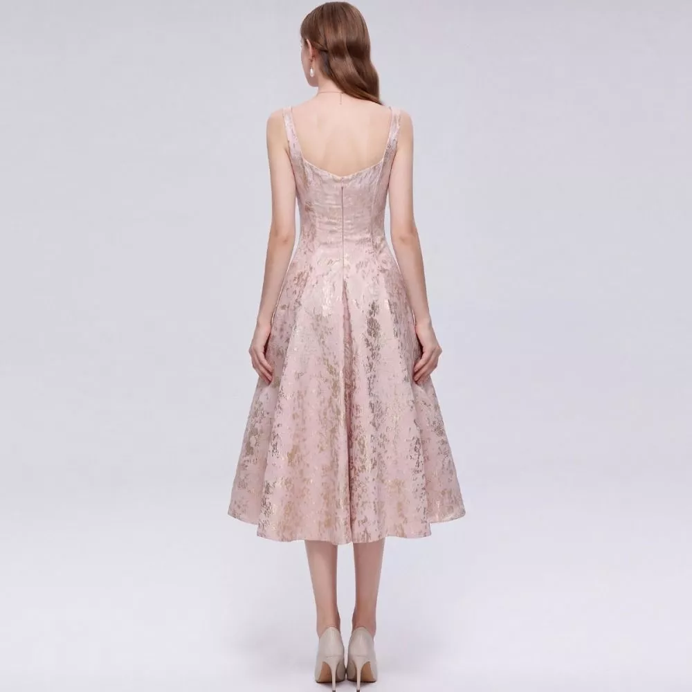 Modella con abito rosa chiaro elegante e orecchini pendenti