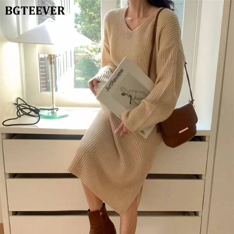 Abito lungo beige chiaro con maniche lunghe e scollo a V indossato da donna con tracolla marrone