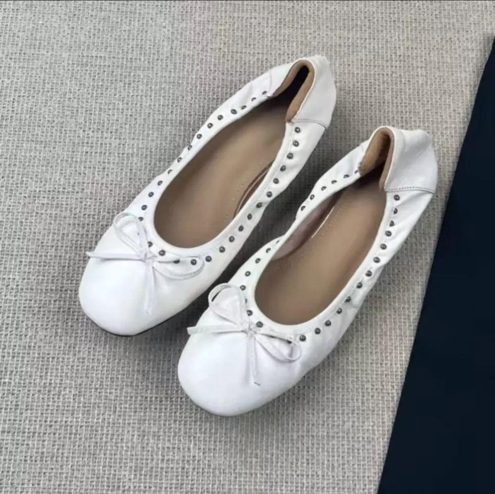 Dettaglio sopra ballerine bianche con fiocchetto e borchie
