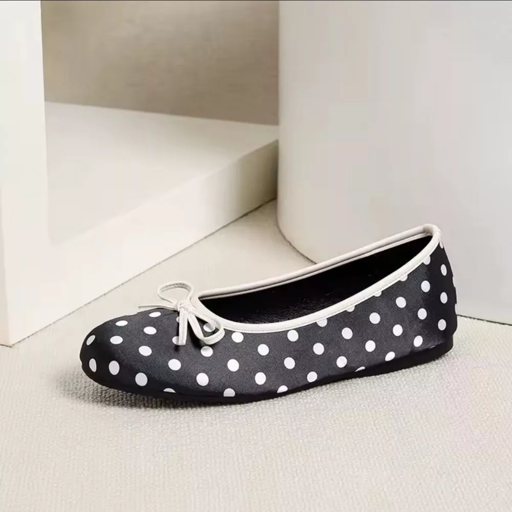 Particolari delle ballerine nero con pois bianchi: vista dall'alto, interno, lato e suola antiscivolo.