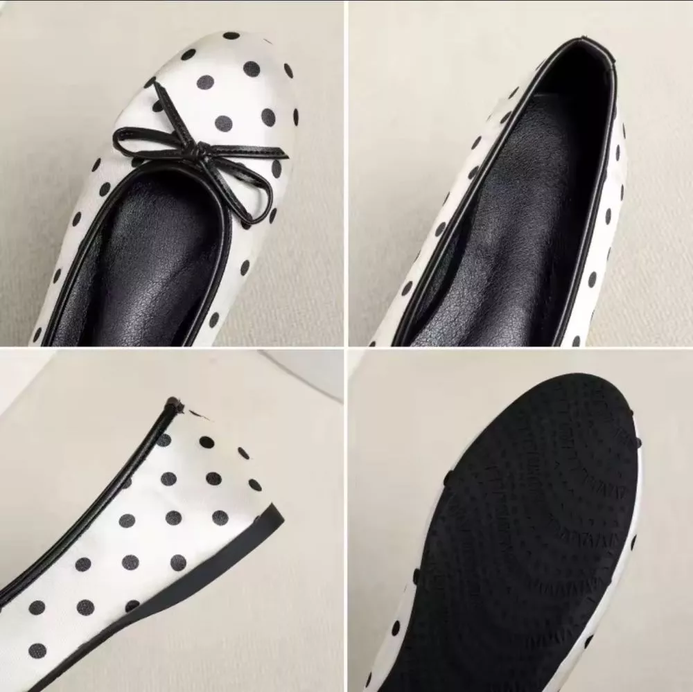 Ballerine donna bianco con pois neri e fiocco, viste lateralmente, su pavimento chiaro.
