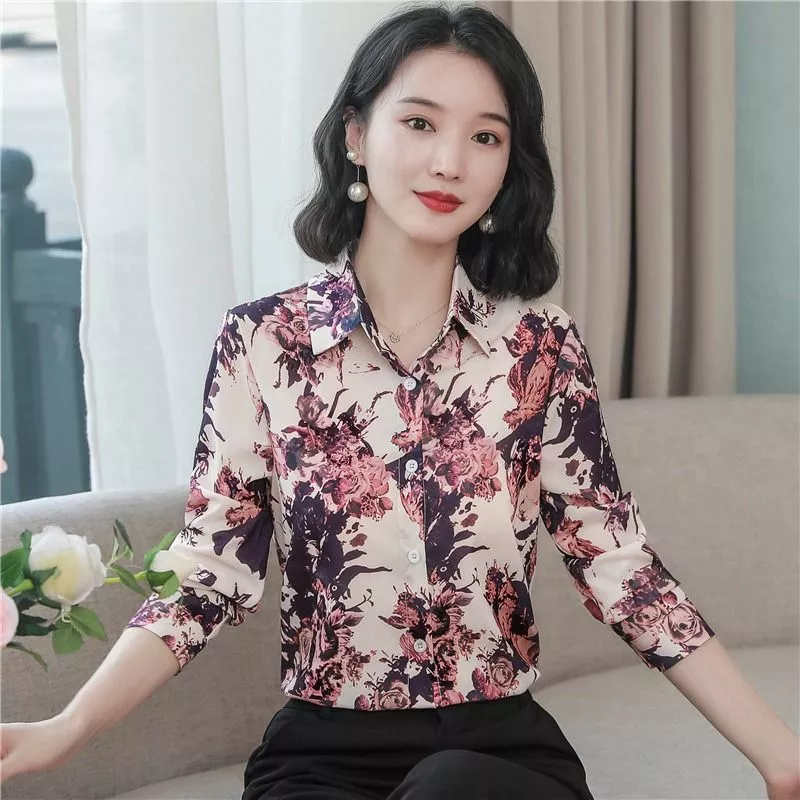 Donna con camicia floreale seduta vicino a finestra
