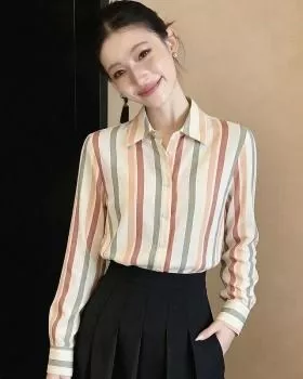 Donna indossa camicia maniche lunghe a righe colorate con gonna nera