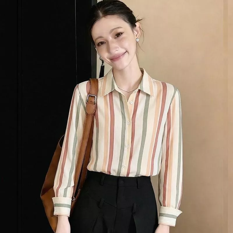 Donna con camicia rigata e borsa marrone su spalla