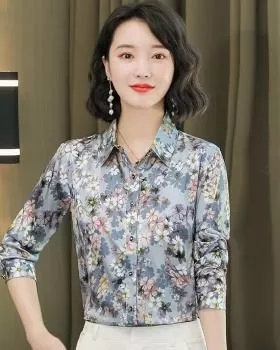 Camicia maniche lunghe con fantasia floreale su sfondo azzurro indossata da donna