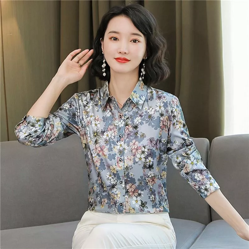 Donna seduta con camicia floreale e pantaloni bianchi