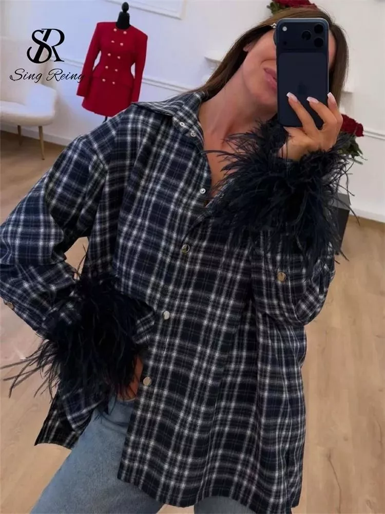 Dettaglio camicia donna quadri blu navy con piume su maniche e bottoni a pressione