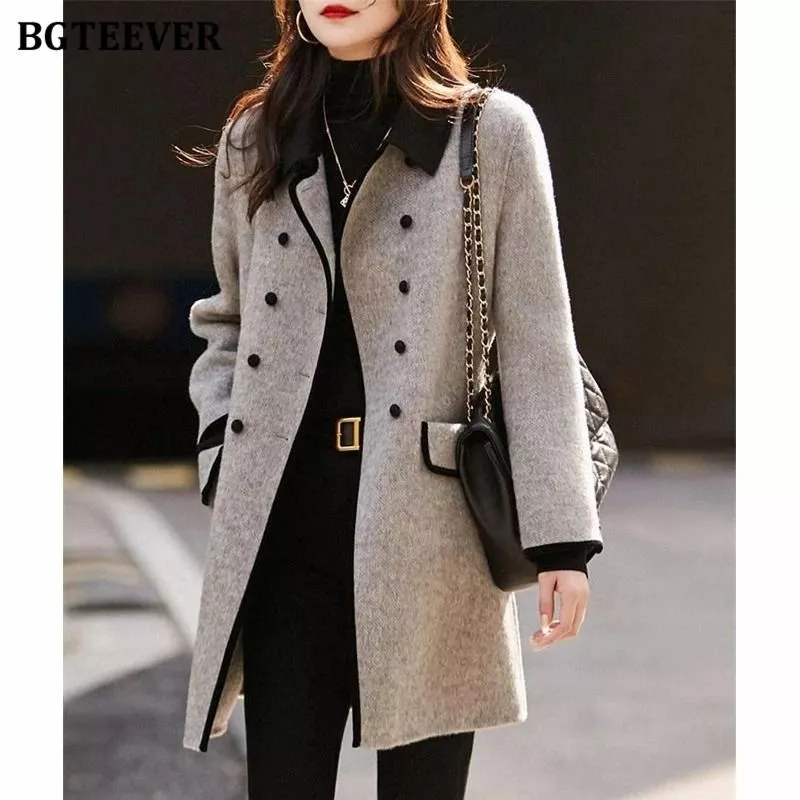 Modella indossa cappotto donna grigio chiaro con bottoni doppi e collo nero a contrasto vista frontale