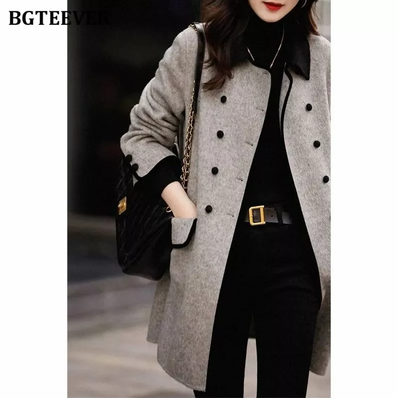Dettaglio manica e tasca cappotto donna grigio chiaro con bordo nero e bottoni neri