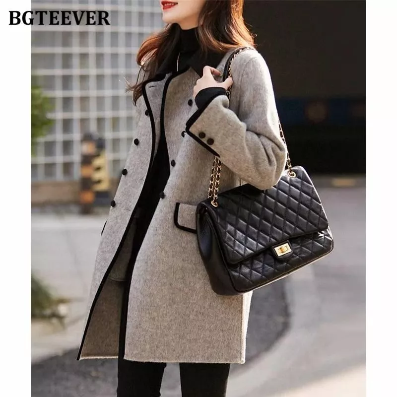 Modella con cappotto donna grigio chiaro con bottoni doppi e collo nero vista laterale