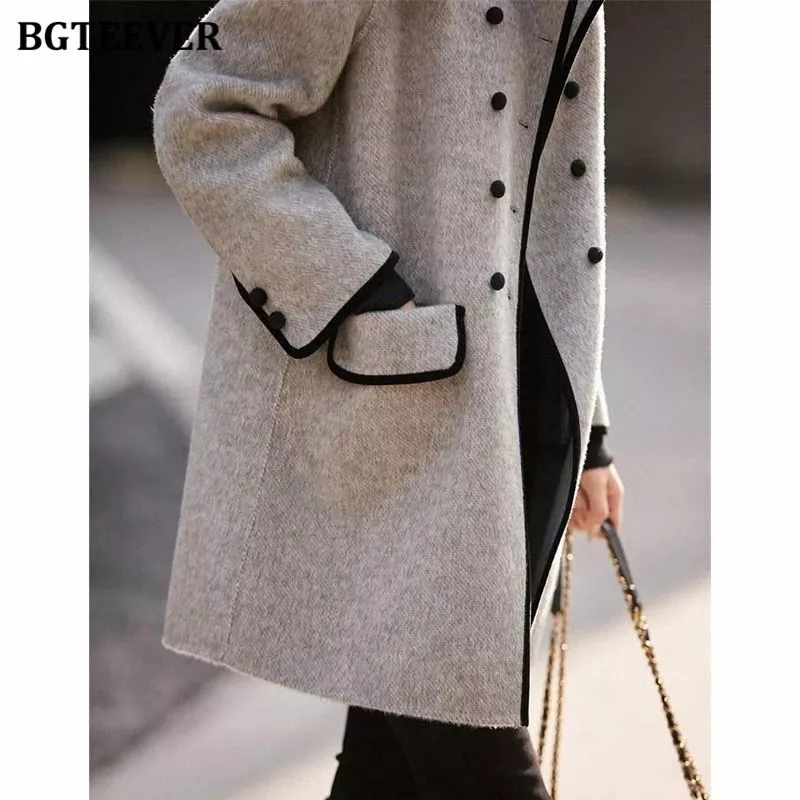 Dettaglio tasca e polsino cappotto donna grigio chiaro con bordi neri e bottoni neri