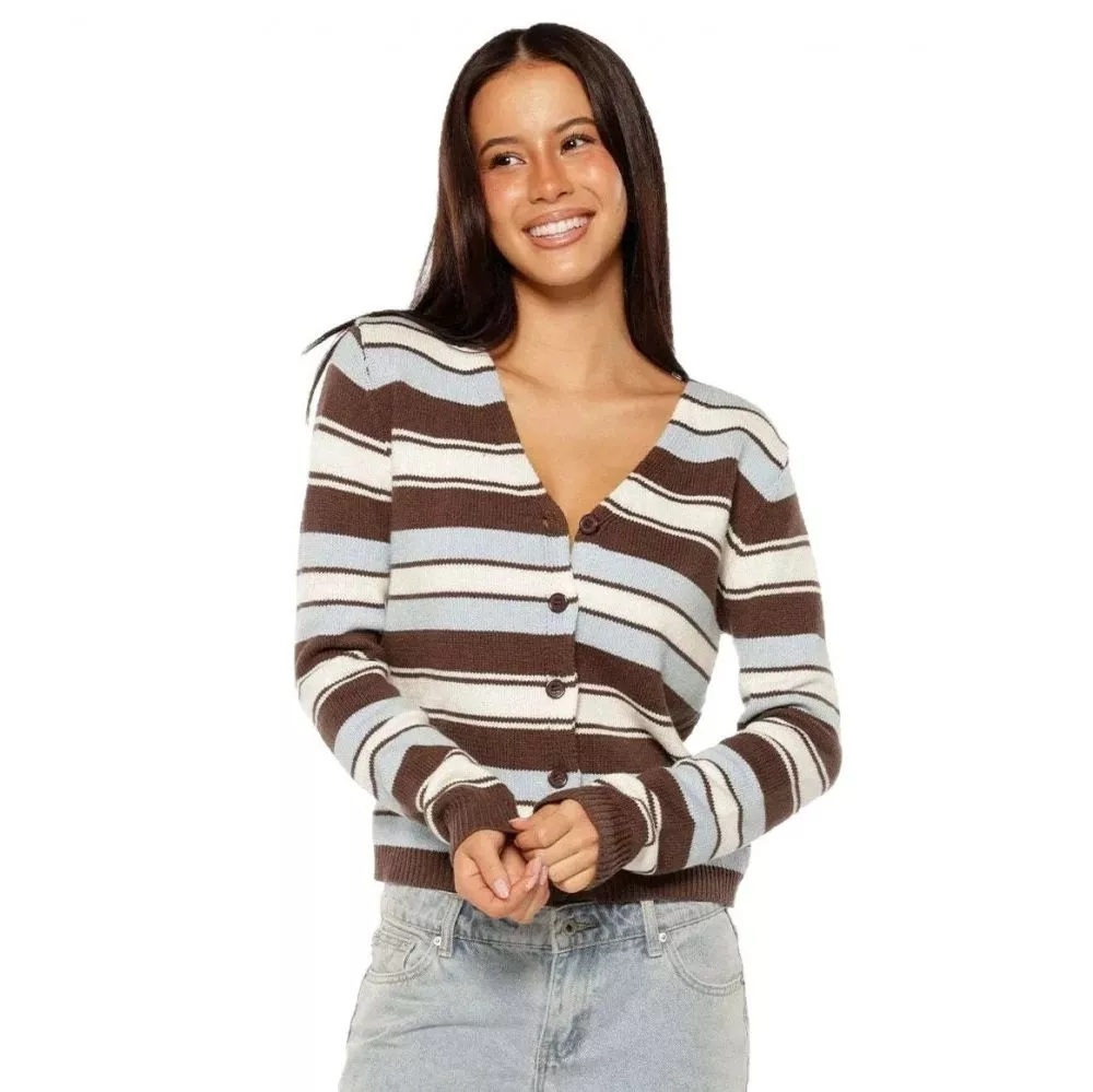 Donna con cardigan a righe marrone azzurro bianco e jeans chiari, posa sorridente