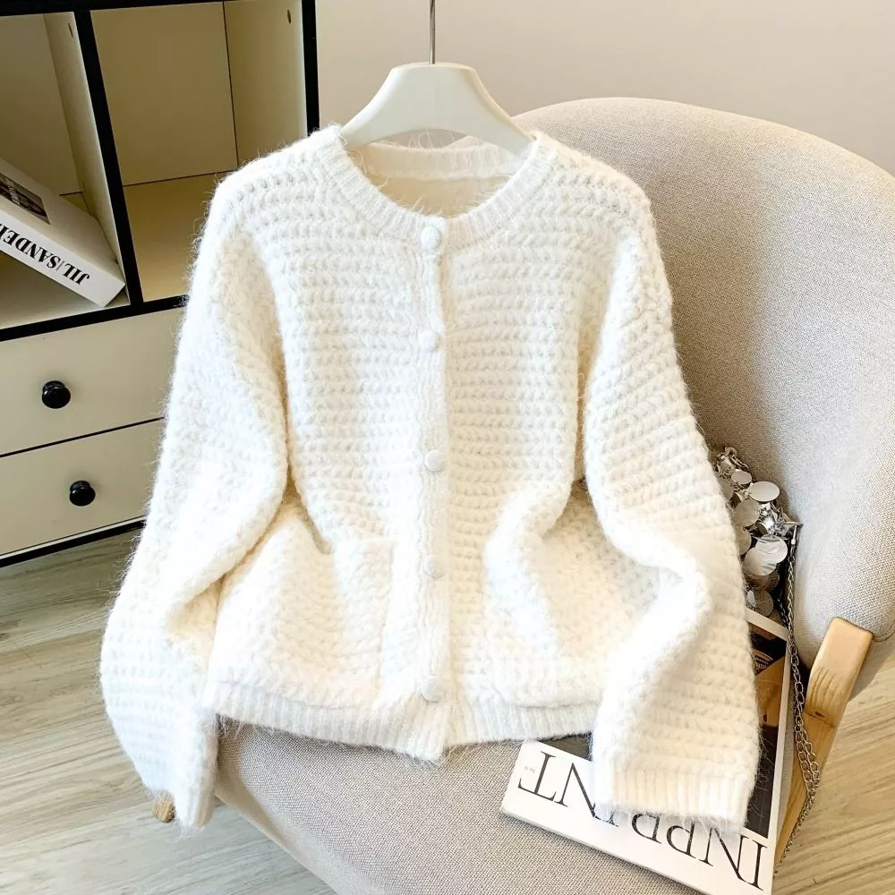 Cardigan bianco donna lavorato a maglia, visto da davanti su sedia