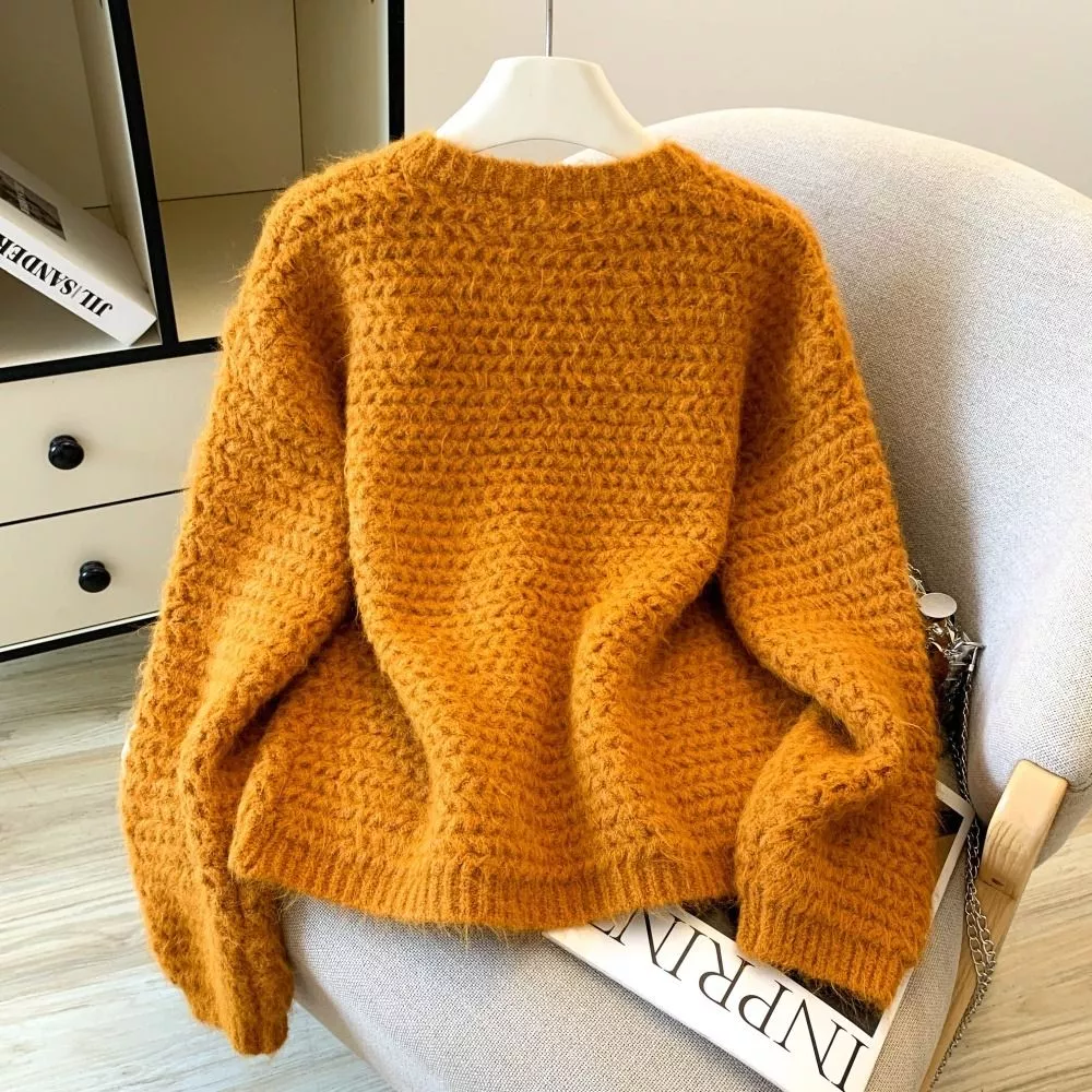 Dettaglio del cardigan grigio in maglia con bottoni rivestiti