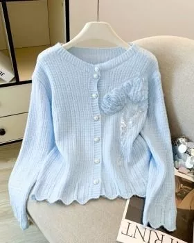 Cardigan donna azzurro chiaro in maglia con decorazione floreale davanti su sedia