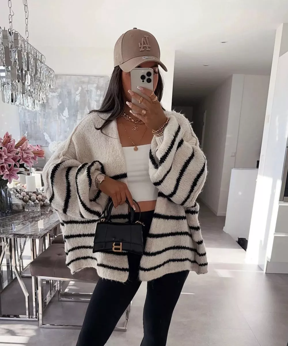Cardigan bianco oversize con righe nere indossato con top bianco e pantaloni neri