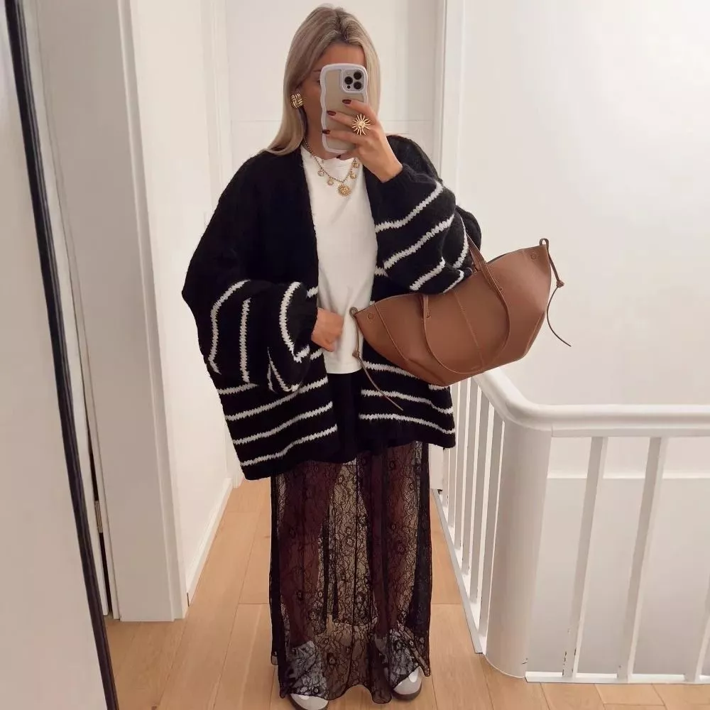 Cardigan nero e righe bianche indossato con maglia e gonna lunga in pizzo nera