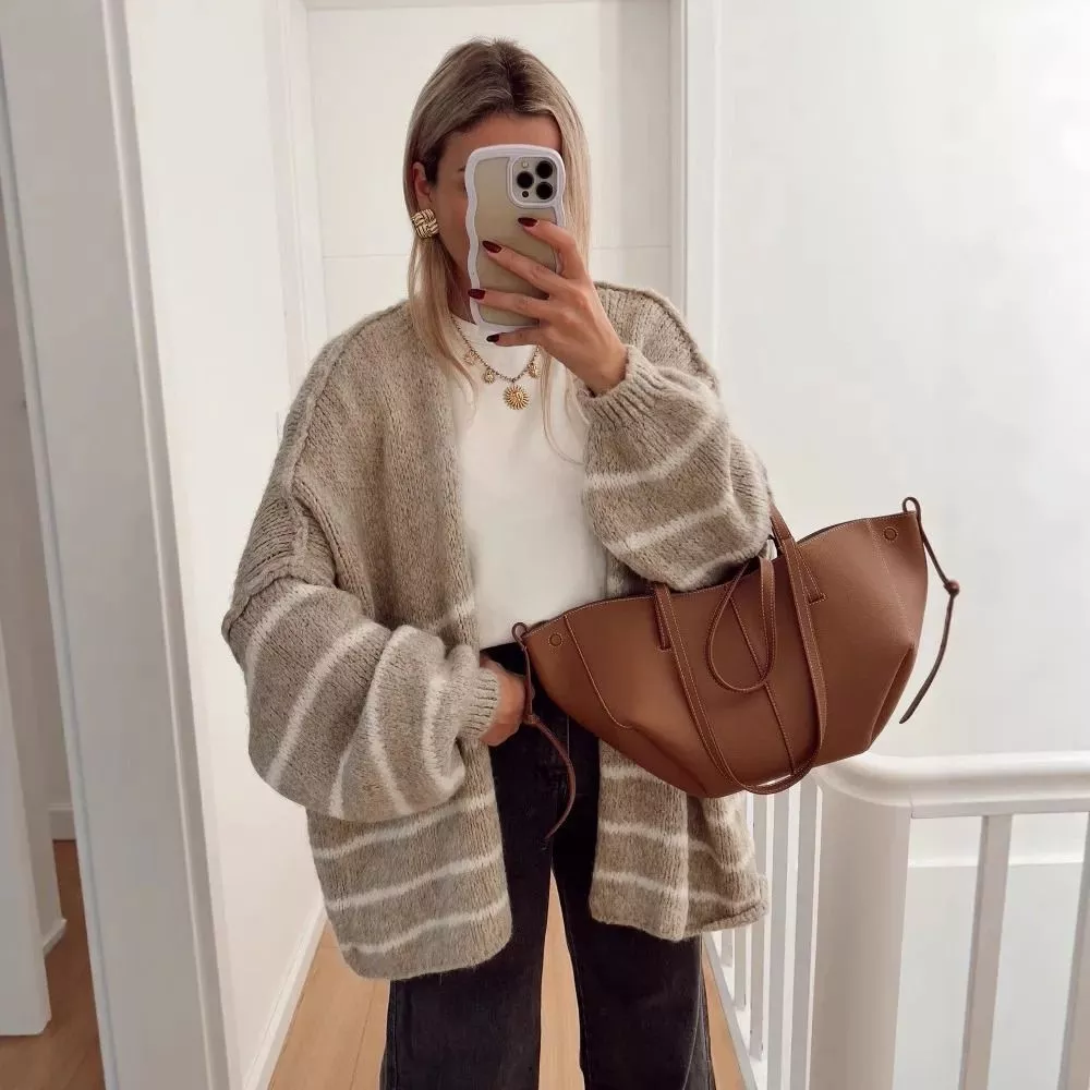 Cardigan beige con righe bianche indossato con maglia bianca e jeans