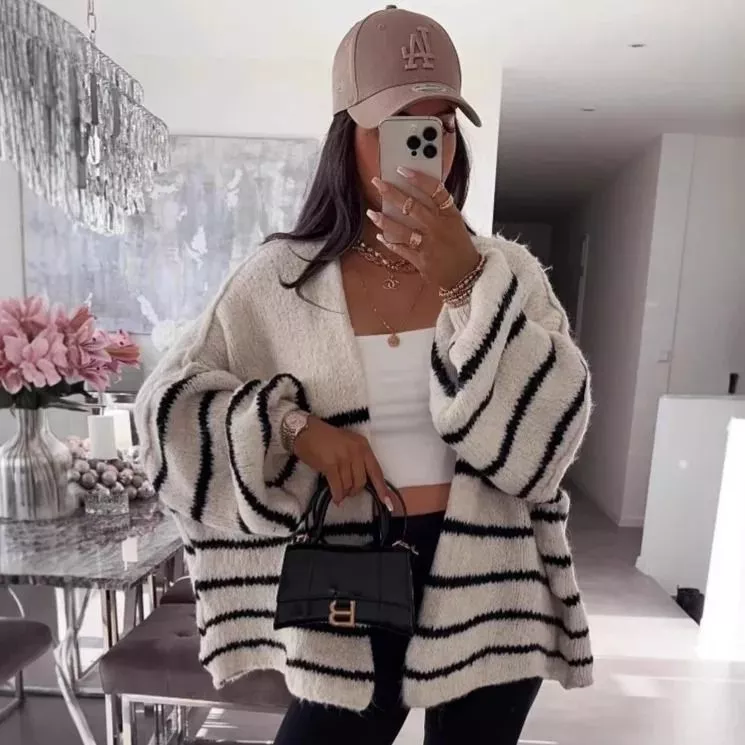 Cardigan nero e righe bianche indossato da modella con borsa nera