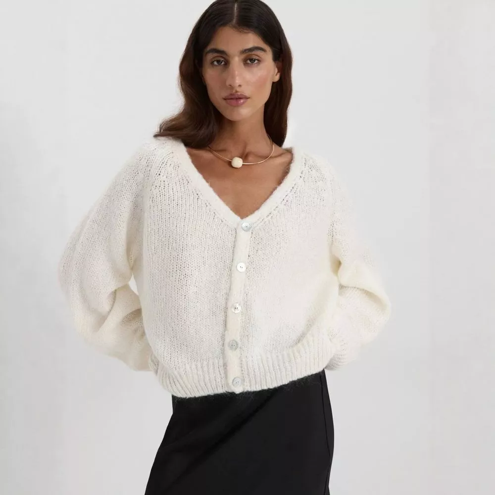 Cardigan donna di colore bianco con bottoni, vista frontale.