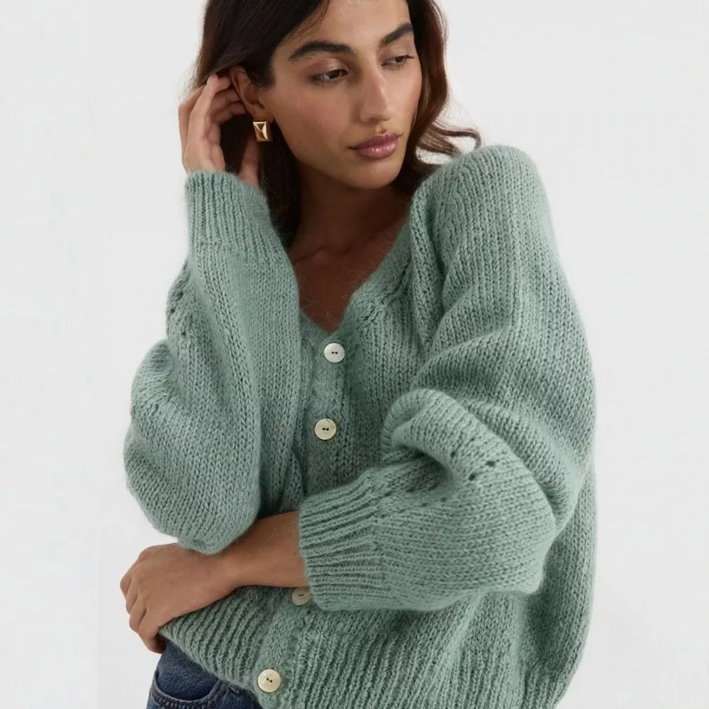 Cardigan verde donna con bottoni, abbinato a jeans, vista frontale.