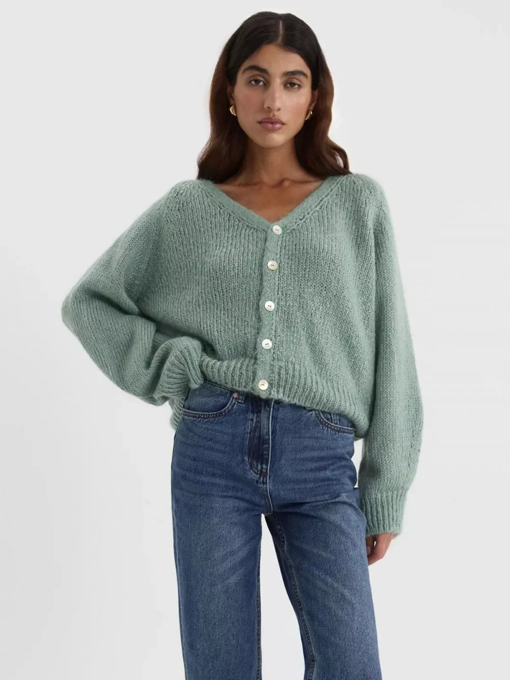 Modella indossa cardigan verde donna con bottoni e jeans, vista laterale.