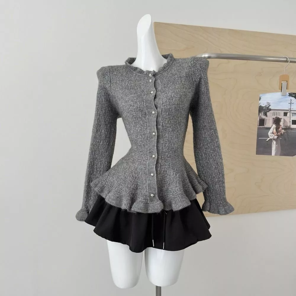 Cardigan donna marrone con bottoni e fondo con balze esposto su manichino