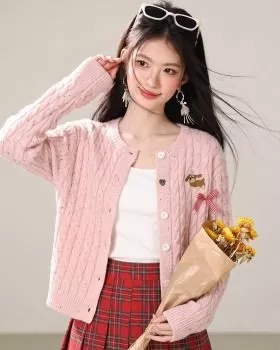 Cardigan rosa lavorato a maglia indossato da donna con gonna scozzese rossa, vista frontale e laterale, dettaglio bottoni