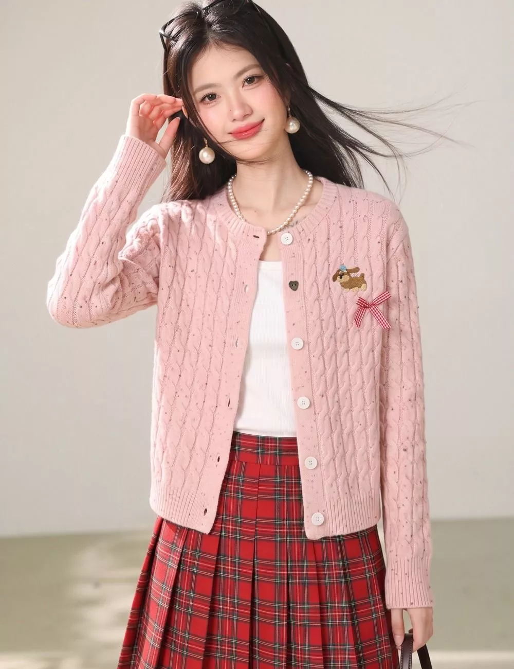 Cardigan rosa aperto con bottoni indossato con accessori moda