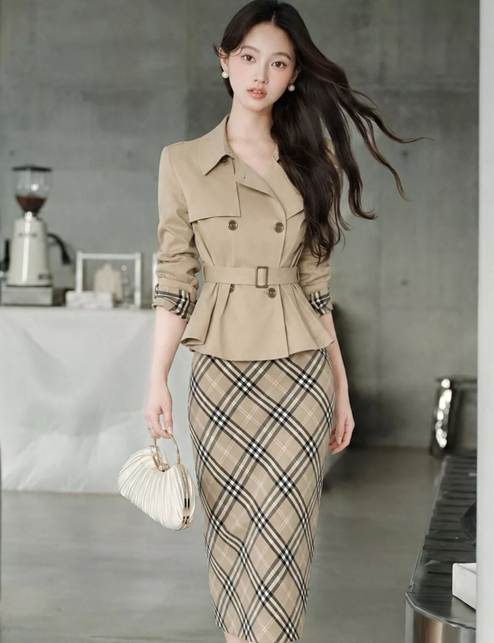 Modello donna con completo due pezzi giacca corta beige e gonna a quadri vista laterale indossato davanti a finestra