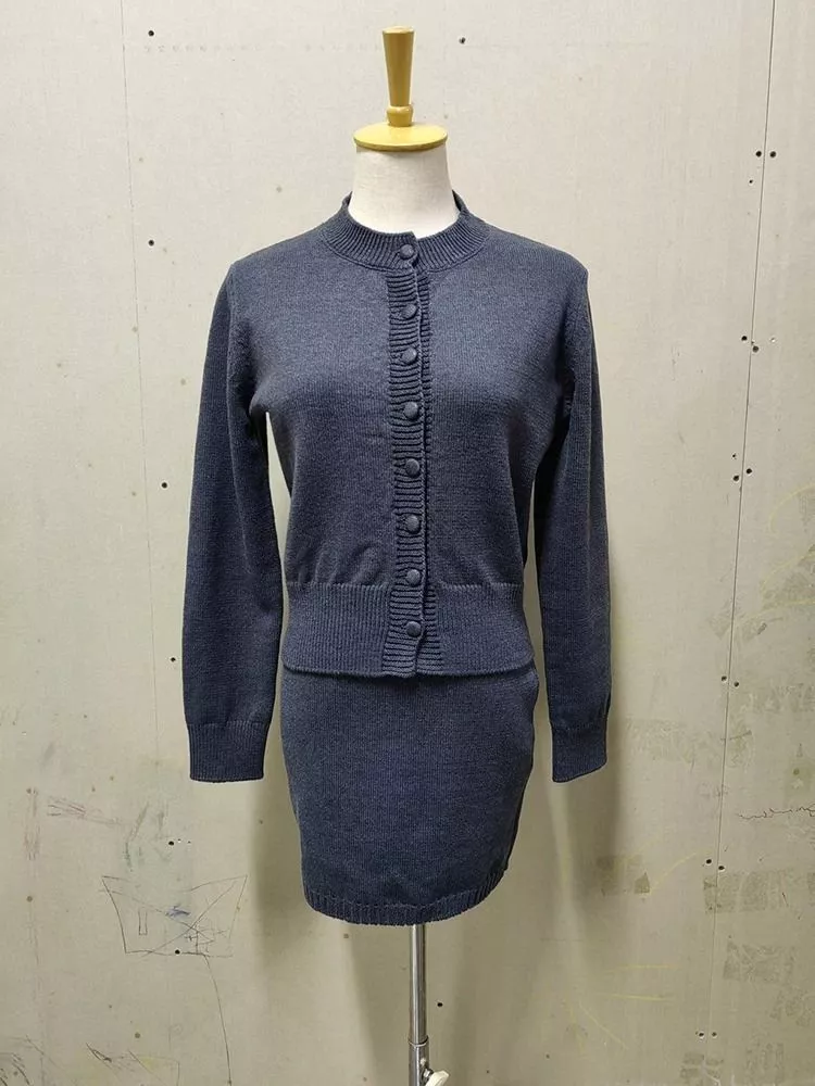 Completo donna maglia e gonna grigio scuro su manichino con bottoni rivestiti