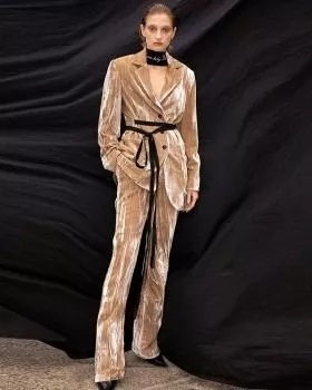 Modella indossa completo donna in velluto rosa chiaro con giacca slim e pantaloni dritti