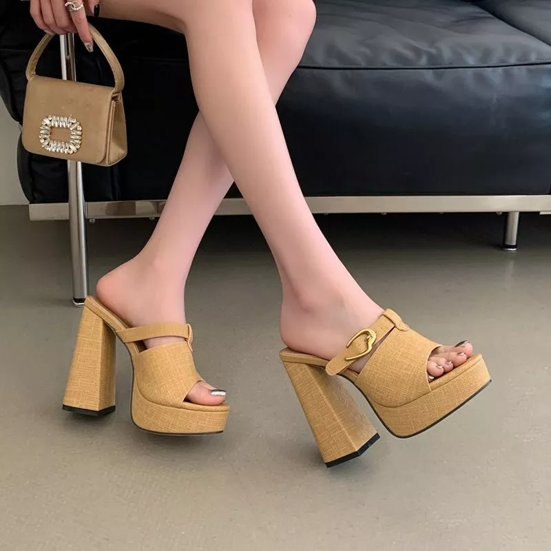 Scarpe sabot beige indossate, donna seduta con borsa beige elegante