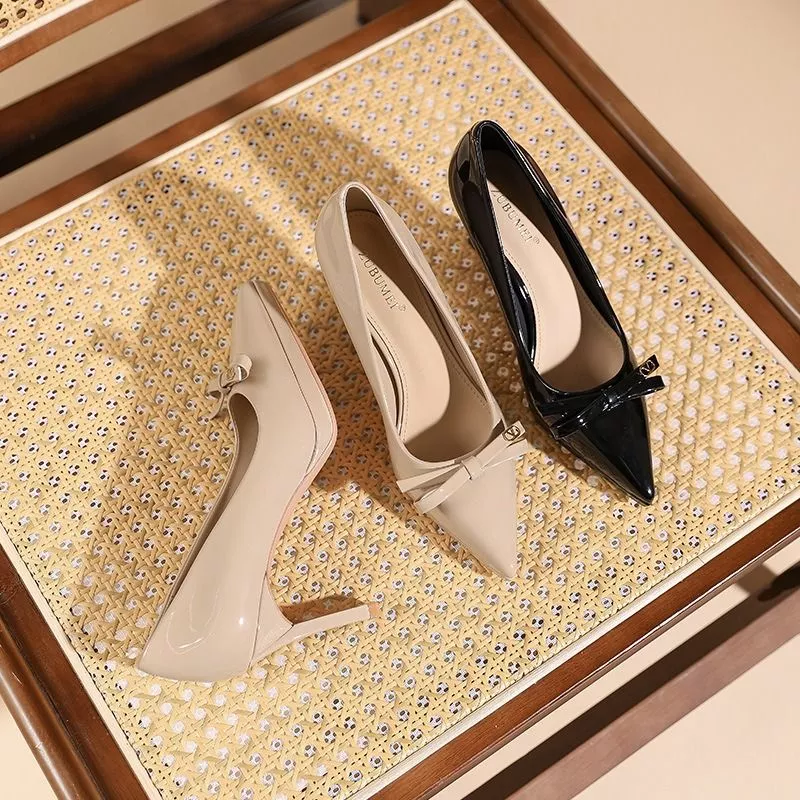 Due d&eacute;collet&eacute; lucide nero e beige chiaro su sedia in legno e vimini