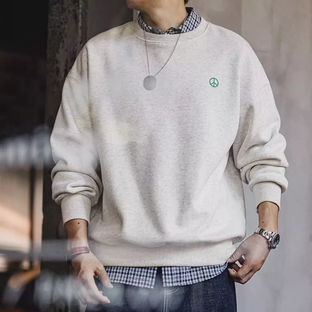 Felpa beige uomo con girocollo e logo verde su modello, vista frontale