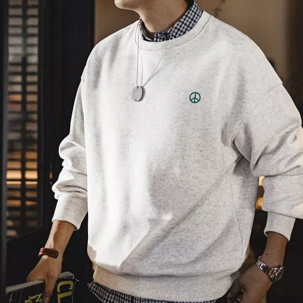 Modello che indossa felpa beige uomo con logo verde, vista frontale
