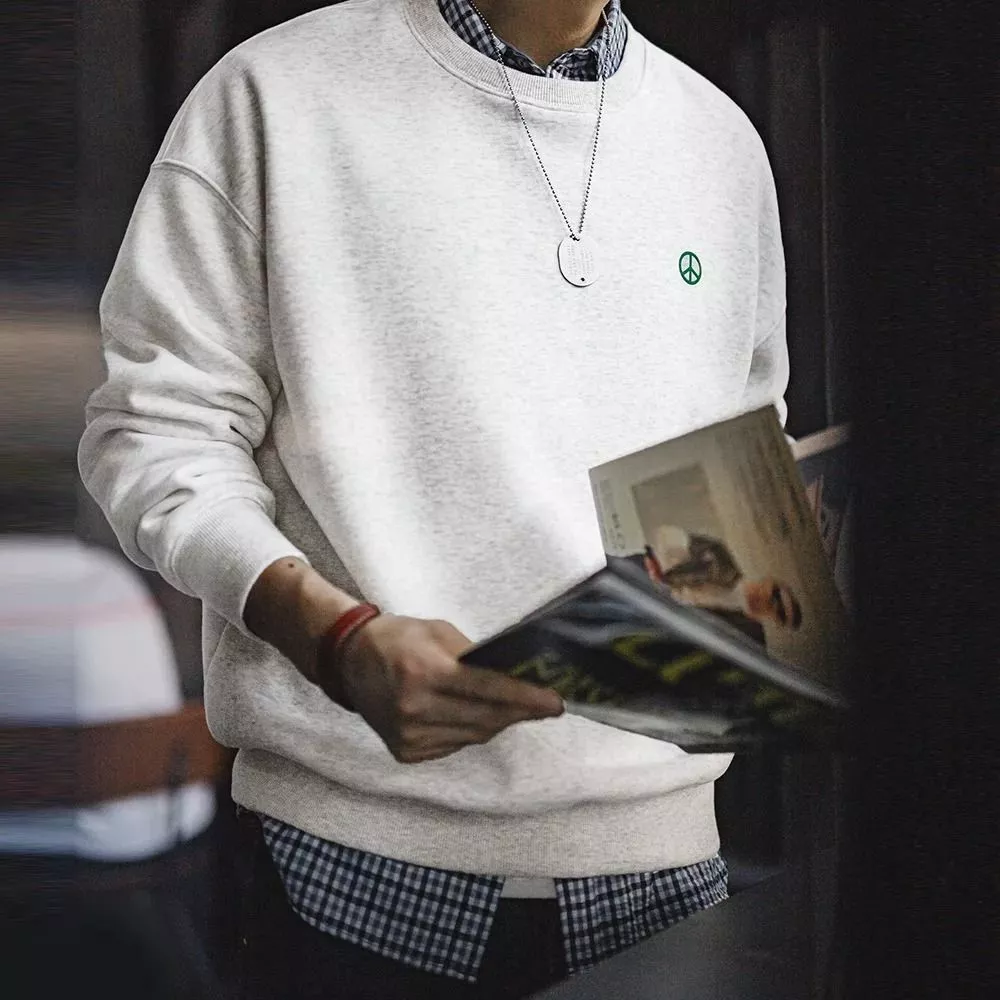 Felpa beige uomo con logo indossata con camicia a quadri sotto vista laterale