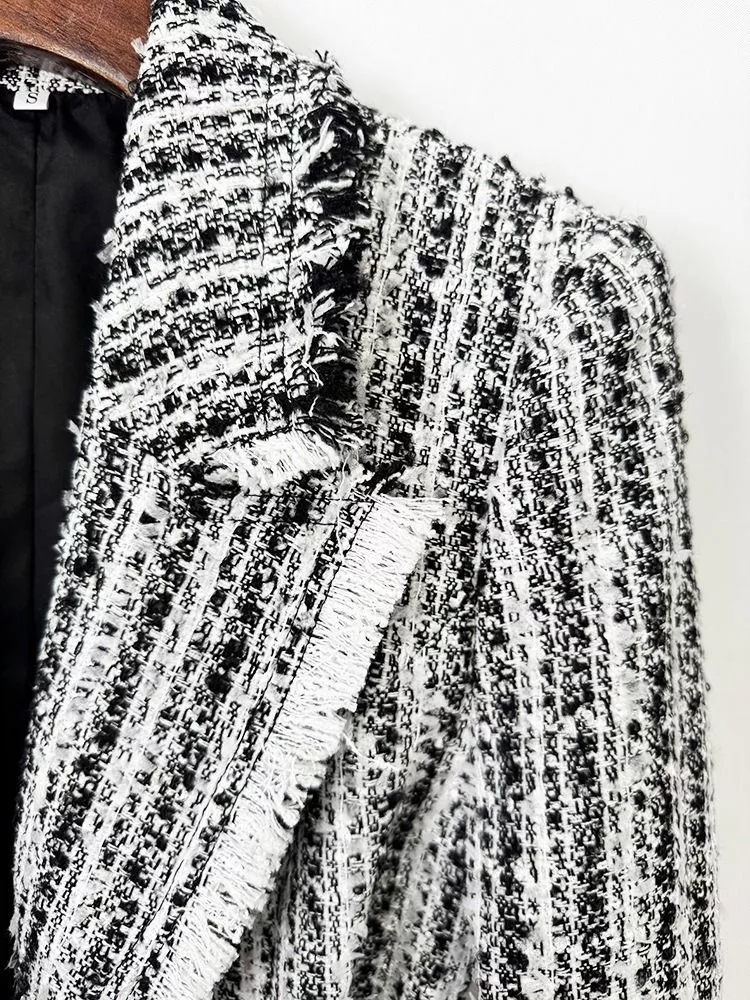 Dettaglio fibbia dorata e cintura della giacca donna tweed bianco e nero