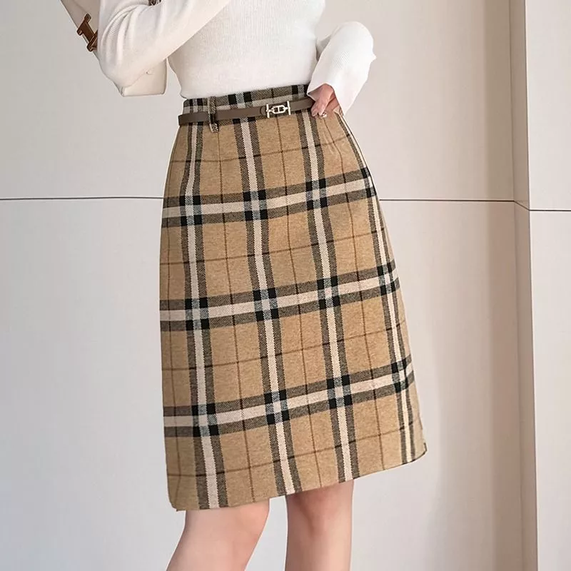 Modella indossa gonna a quadri cachi con maglia bianca e cintura sottile