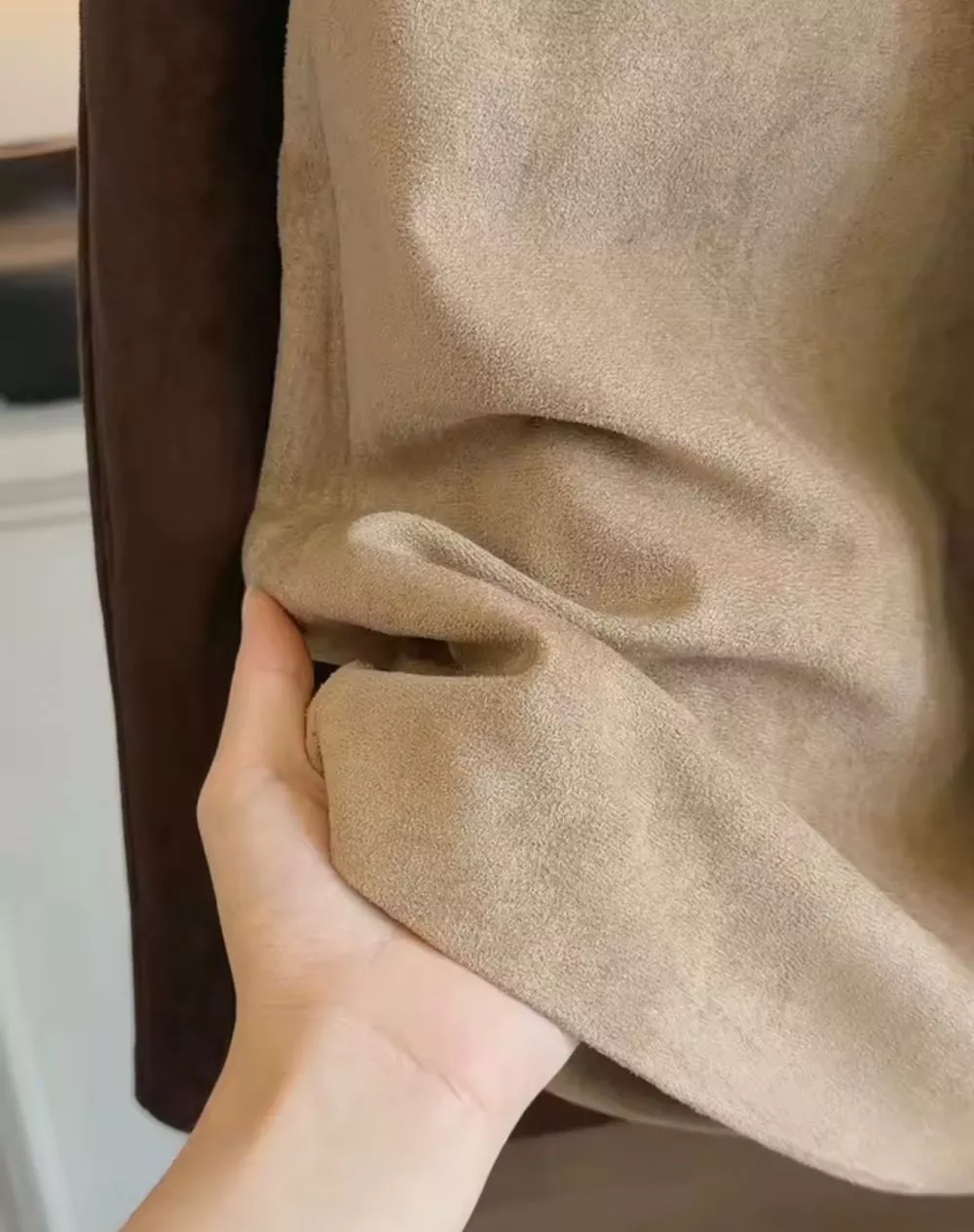 Dettaglio tessuto della gonna beige chiaro con gonna marrone scuro accanto
