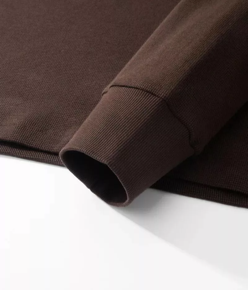 Primo piano di polsino elasticizzato di maglia marrone a trama fine