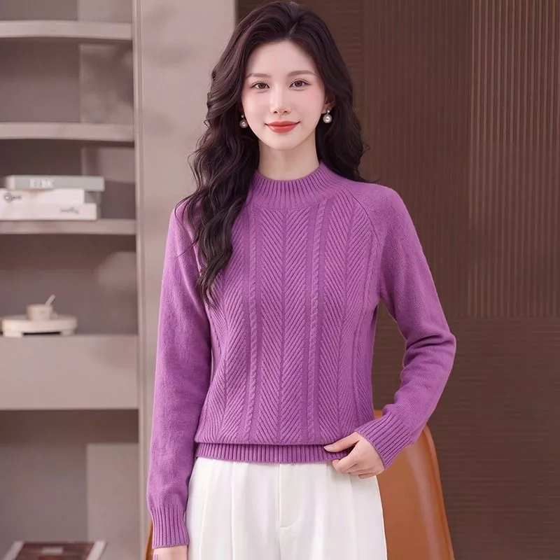 Donna con maglione viola a collo alto a giro in posa frontale con mano sulla vita