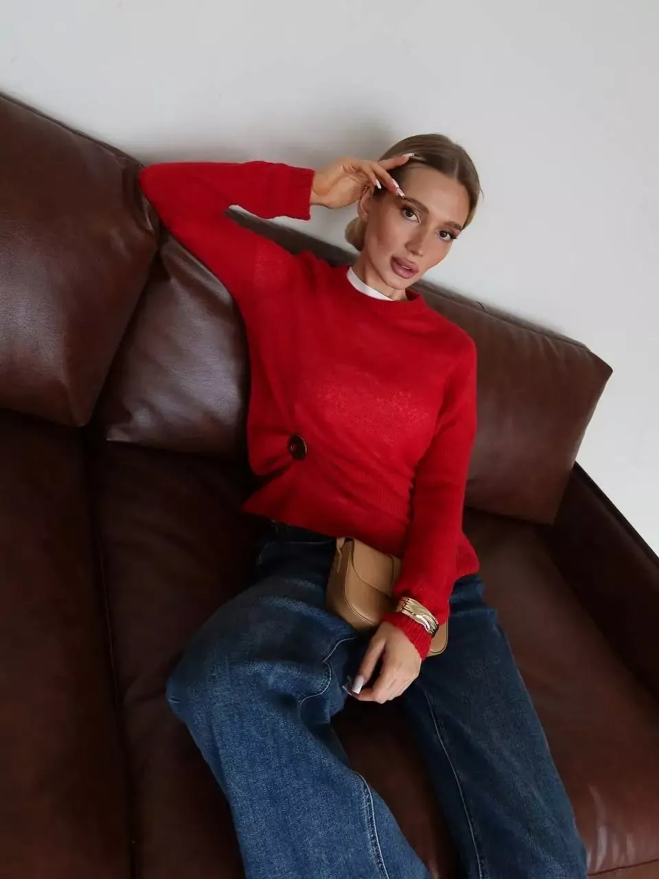 Maglione donna rosso a collo alto e maniche lunghe indossato sul divano