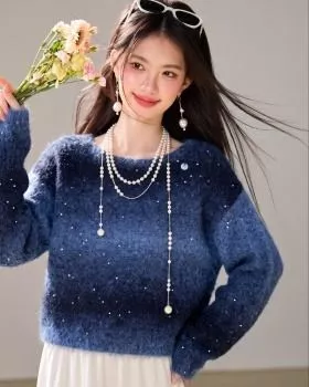 Maglione donna blu sfumato con maniche lunghe e decorazioni luccicanti, indossato con gonna bianca