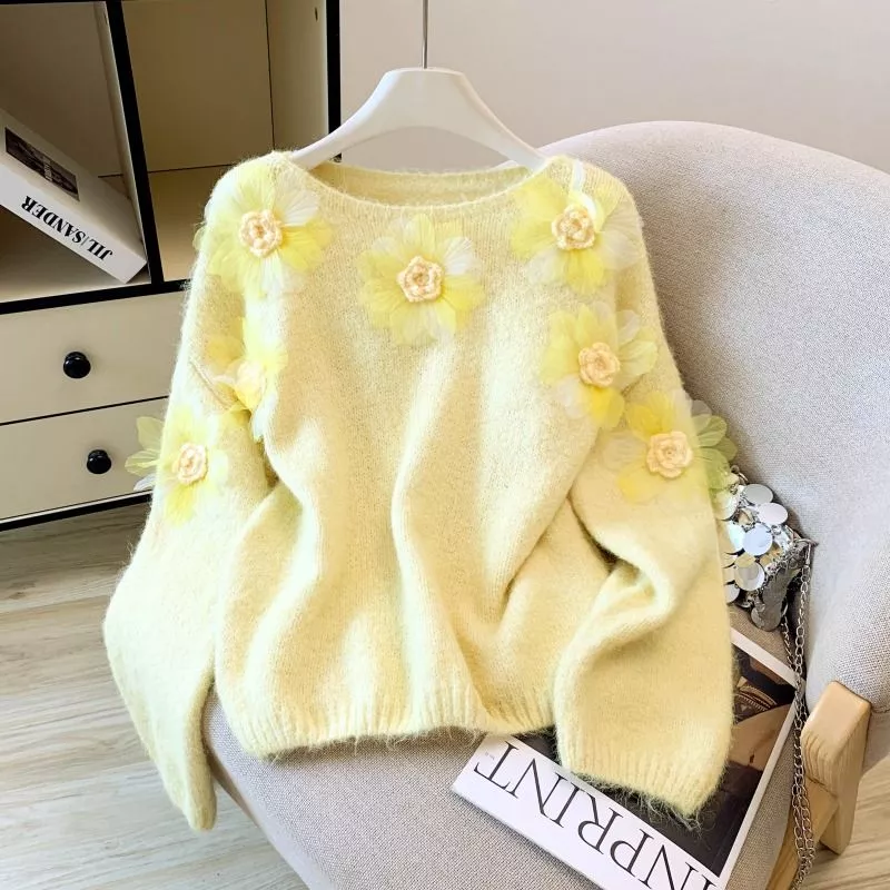 Maglione donna giallo con fiori decorativi gialli appeso su gruccia