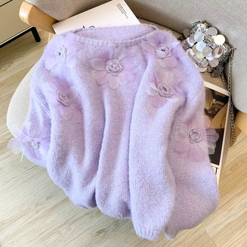 Maglione donna viola con fiori decorativi viola posto su sedia