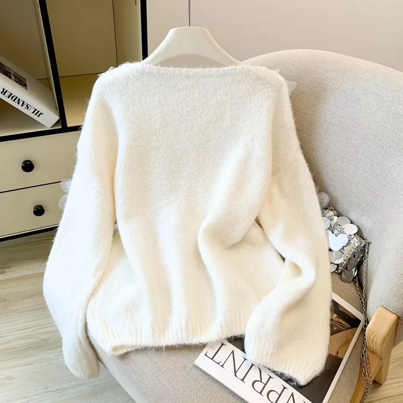 Vista retro maglione donna bianco steso su sedia