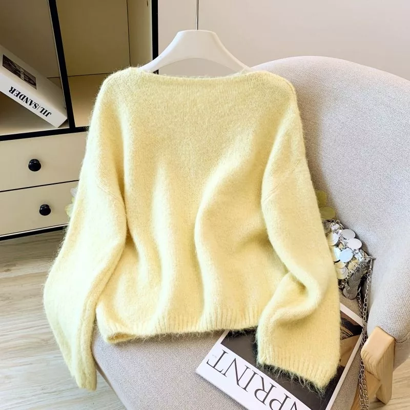 Vista retro maglione donna giallo appeso su gruccia