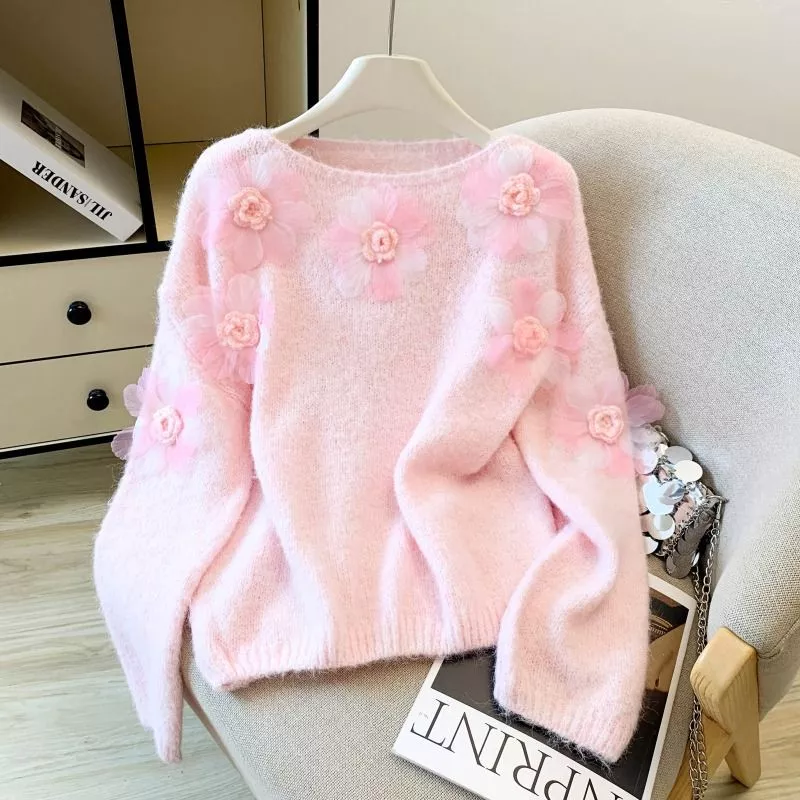 Vista frontale maglione donna rosa con fiori lasciato su sedia